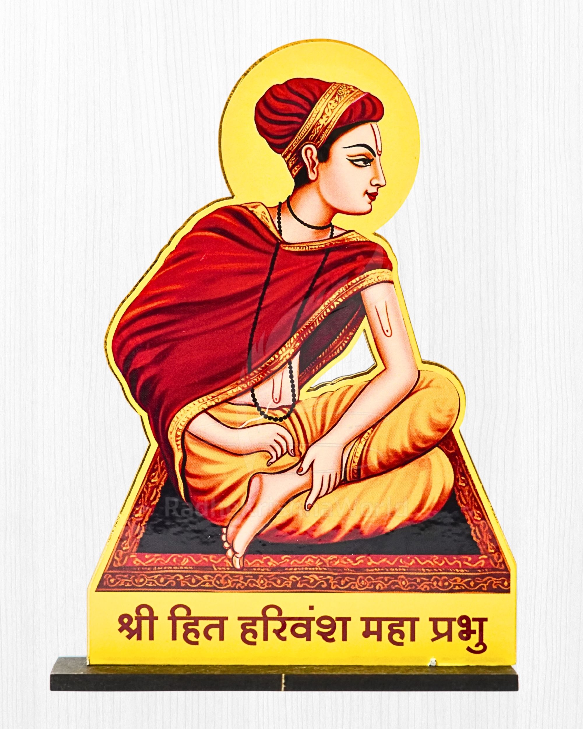 Cutout illustration of a Hindu saint in saffron robes with a yellow halo, seated in a prayerful pose on a decorative base.