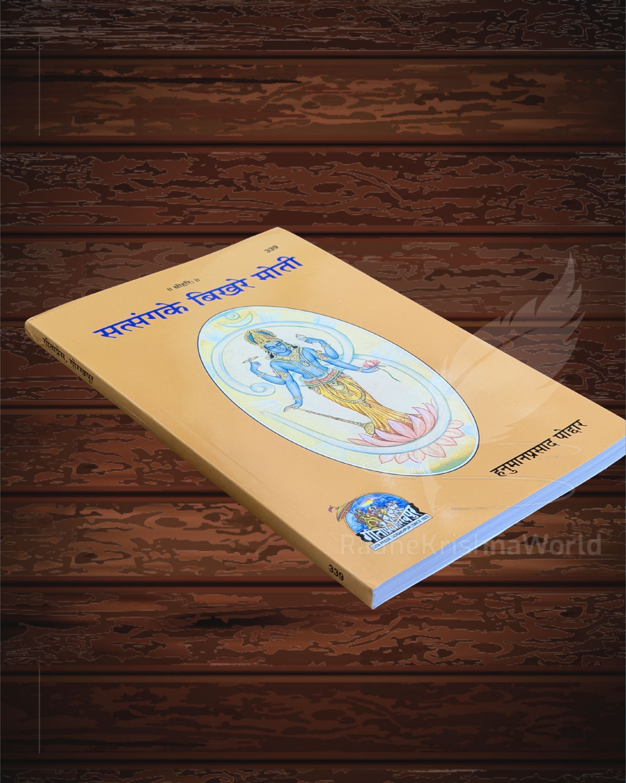 Yellow book cover with a colorful Hindu deity illustration, Devanagari title, lying on dark wooden planks.