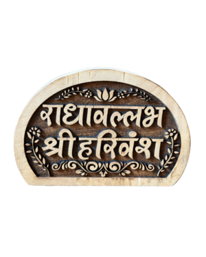 Close-up of a round, carved wooden plaque with decorative floral border and stylized script.