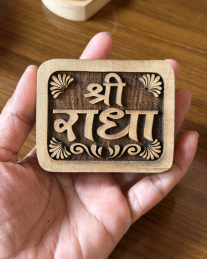 Close-up of a wooden rubber stamp in a hand, showing carved letters spelling 'great' with decorative flourishes in the frame.